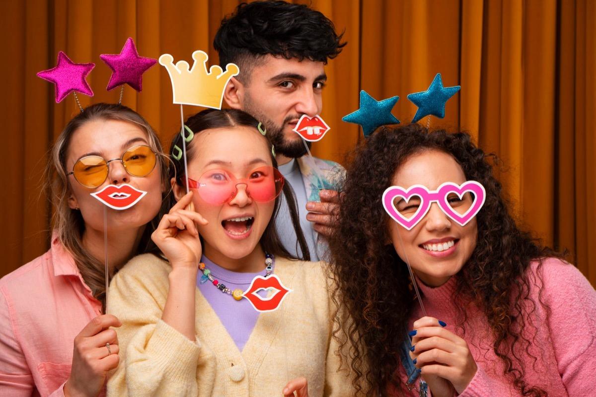 A group of guests crowding into a photo booth with props