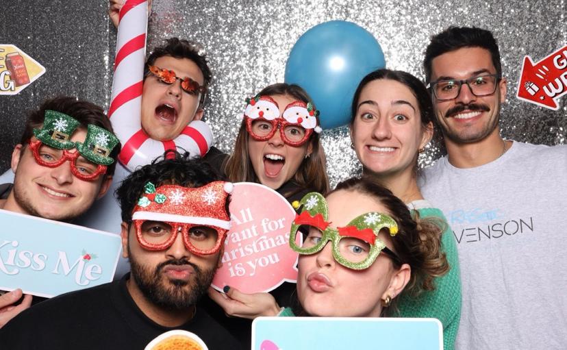 Company holiday party guests with props in a photo booth