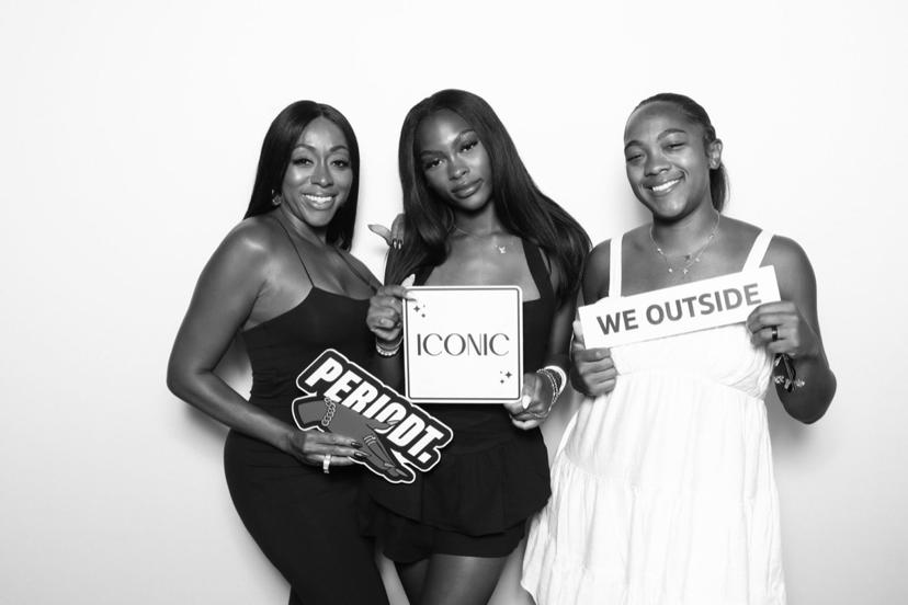 Black and white photo booth shot of friends with signs
