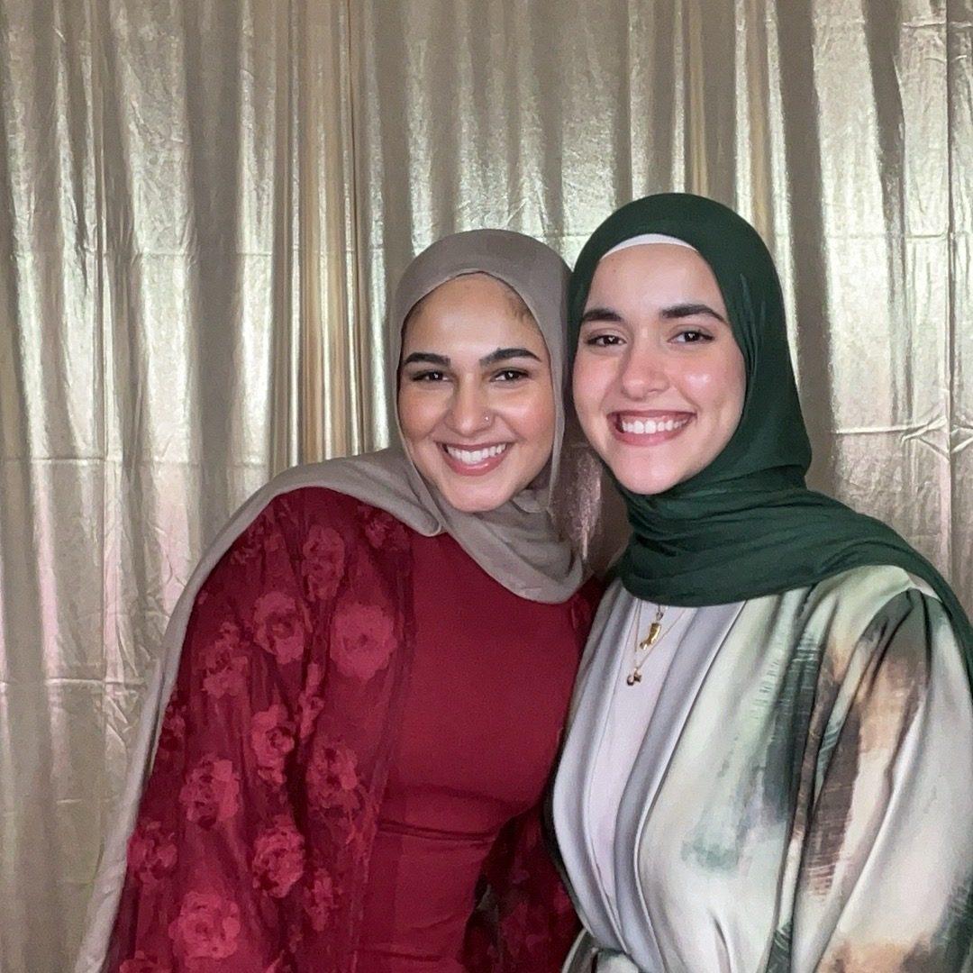 Two guests smiling together in a photo booth at a formal banquet