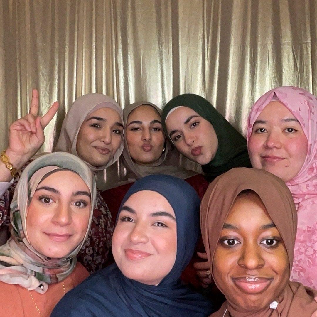 Seven friends crowded into a photo booth selfie at a Philadelphia university event