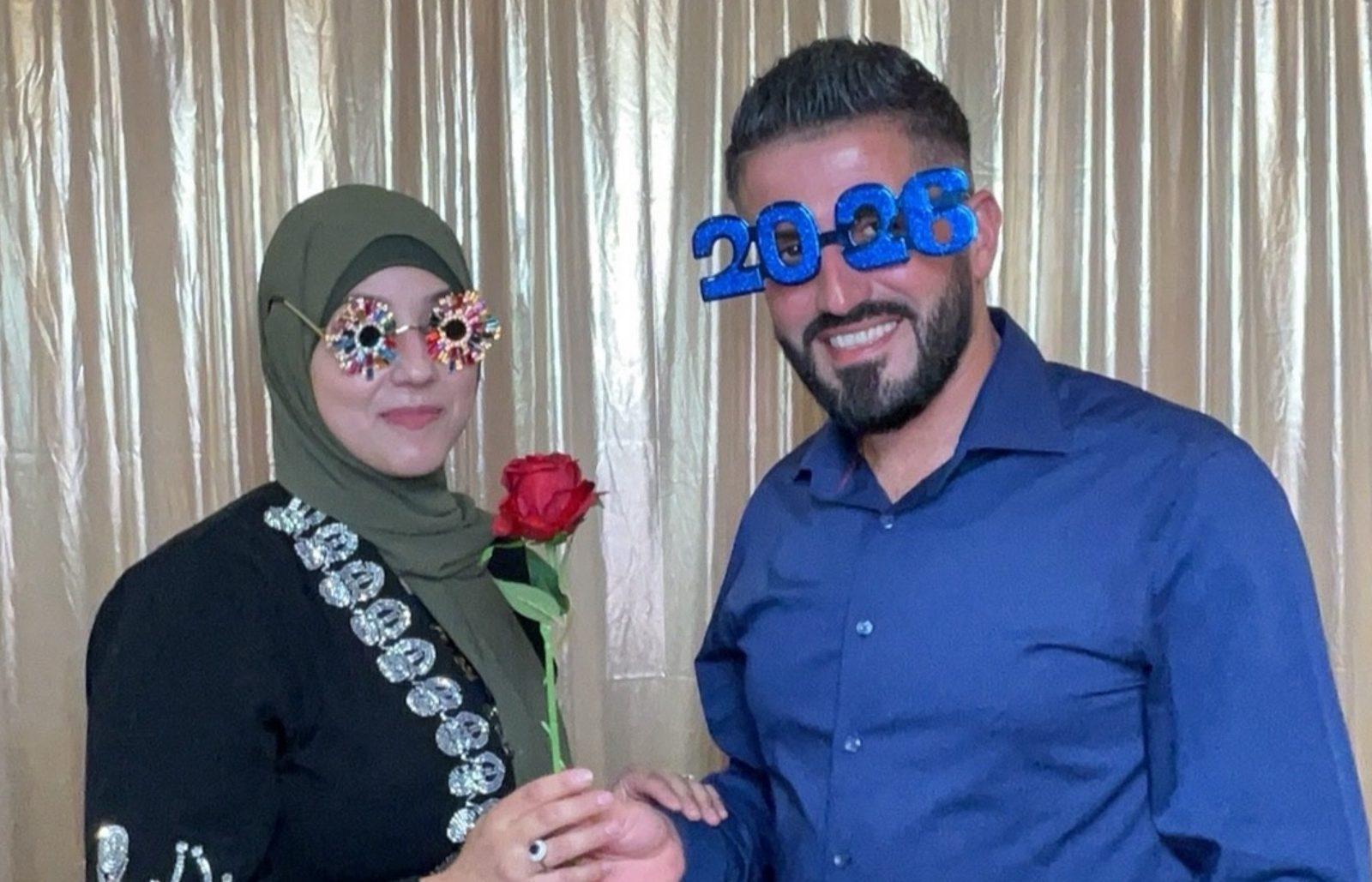 Couple having fun with 2026 novelty glasses and a rose in a graduation photo booth
