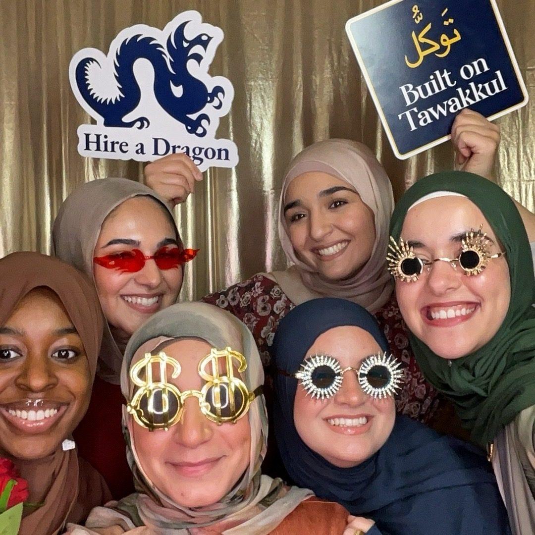 Energetic group with fun glasses and custom prop signs in a Philadelphia photo booth